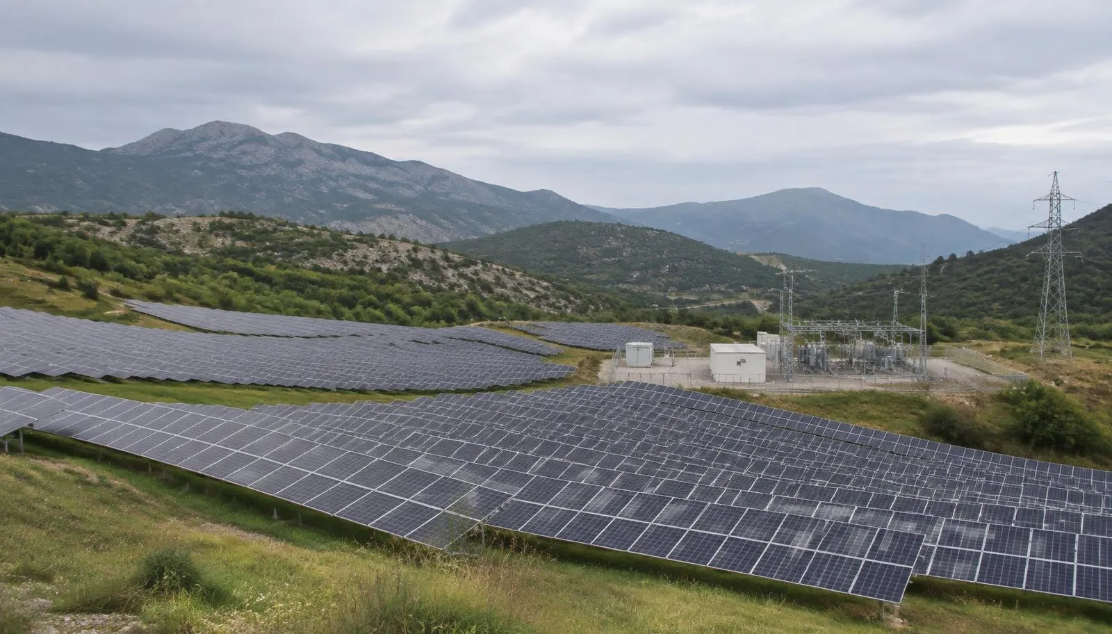 Ein Banker und eine Energieingenieurin prüfen Messdaten in einem Solarpark neben einer Hochspannungsleitung in den Hügeln des Balkans.
